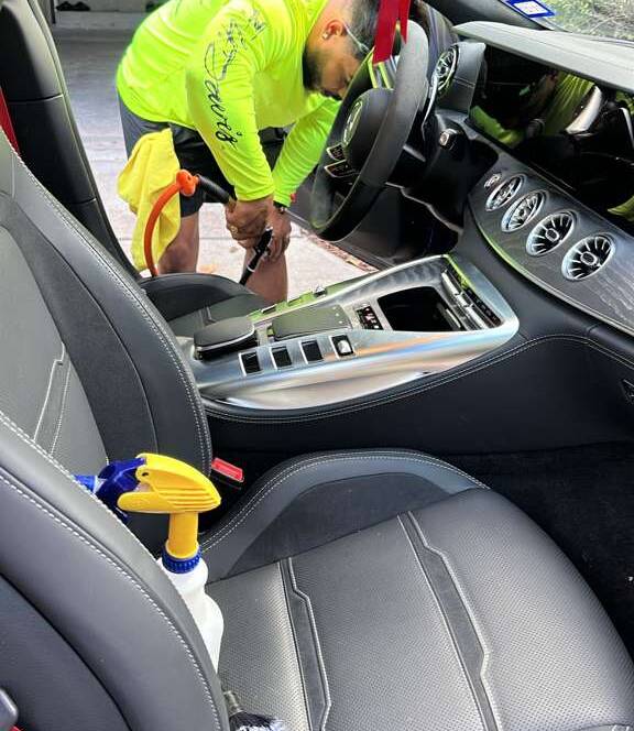Interior detailing service in Orlando by a technician cleaning the inside of a car.